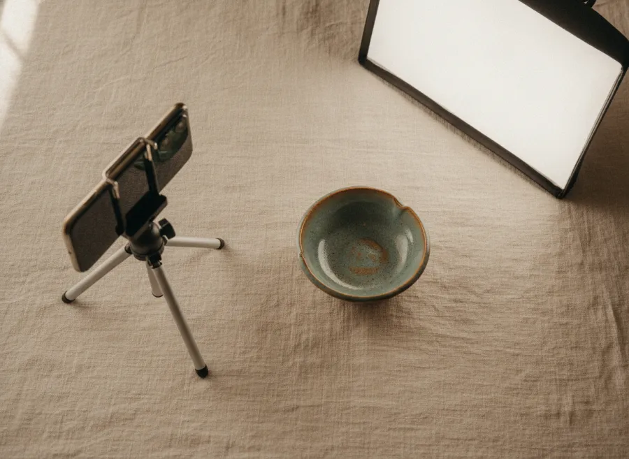A small handmade dish being photographed on a linen backdrop